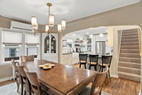 Inviting dining space with a wooden table and stylish decor, connected to a modern kitchen.
