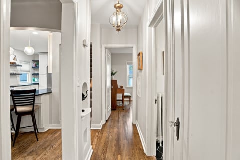 Welcoming hallway with hardwood floors and elegant fixtures, connecting various rooms of the home.