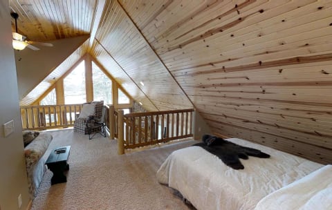 An inviting attic bedroom featuring wooden ceilings and warm decor.