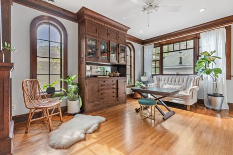 Cozy living room with wooden accents, a tufted sofa, and plants.