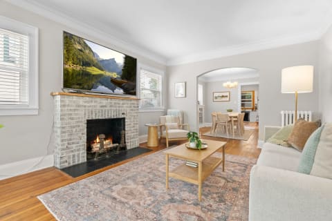 A modern living room featuring a fireplace, TV, and wooden furniture.