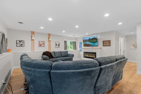 Cozy living room with blue sectional sofa, fireplace, and colorful artwork.