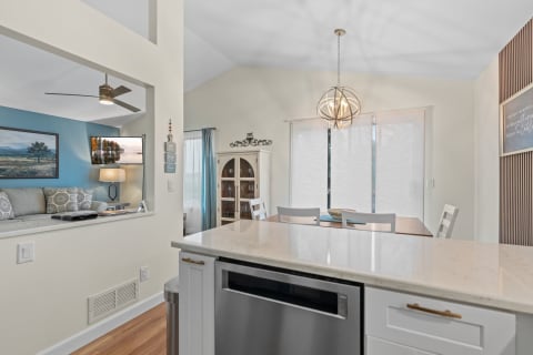 An open concept living space featuring a kitchen island, dining table, and a cozy living area with a couch.