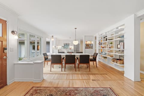 Bright and airy dining room with modern furniture and a view of the kitchen.