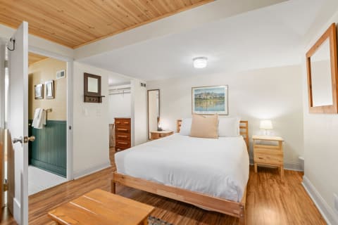 Cozy bedroom with a double bed, wooden furniture, and an attached bathroom.