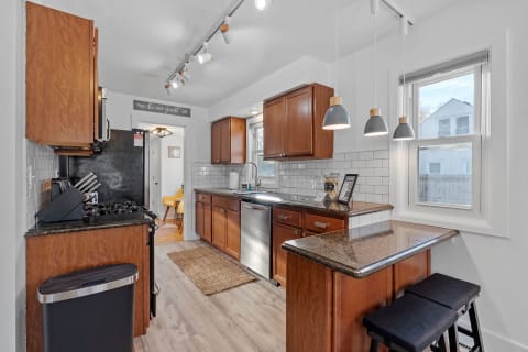 Interior view of a modern kitchen with wooden cabinets and a granite countertop.