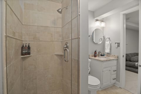 Modern private bathroom with walk-in shower and stylish vanity.