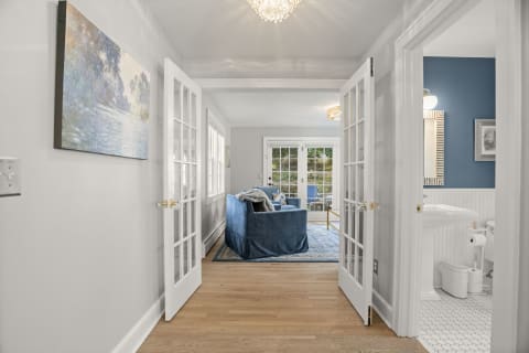 Bright hallway with French doors leading to a living room and bathroom.