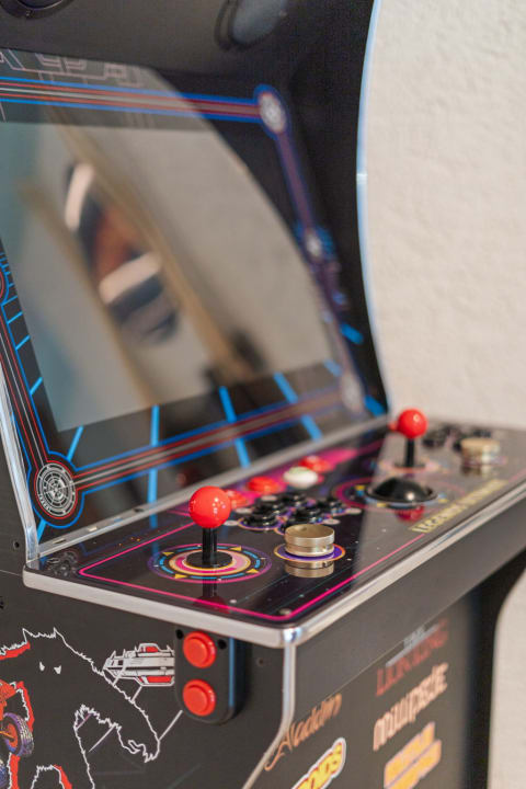 Close-up of a retro arcade machine with colorful buttons and joysticks.