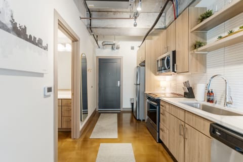 Modern kitchen featuring light wood cabinets and stainless steel appliances.