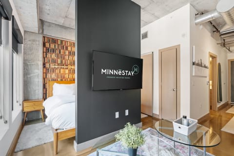 Interior view of a vacation rental featuring a bed, decorative wall, and flat-screen TV.