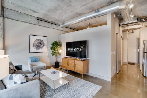 Stylish apartment living room with gray sofa, modern coffee table, and flat-screen TV.