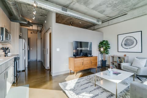 Open living space featuring a kitchen, sitting area, and wooden furniture in a contemporary style.
