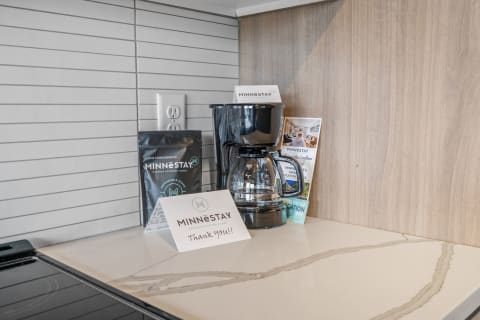 Coffee maker and coffee bag from MINNESTAY on a kitchen countertop with a thank you note.