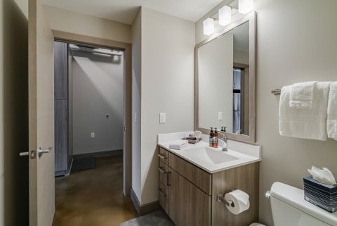 Interior view of a stylish modern bathroom with a vanity, sink, and towels.