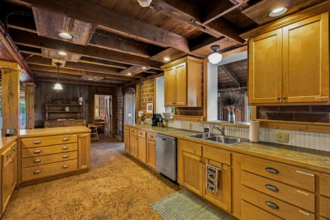 A cozy rustic kitchen featuring wooden beams and golden cabinets, showcasing a warm atmosphere for cooking.