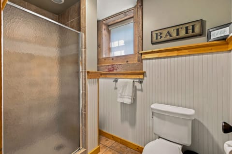 Private bathroom featuring a walk-in shower, rustic wood details, and white towels.