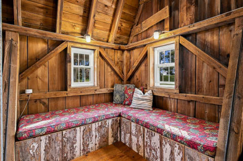 Cozy rustic nook with cushioned seating and warm wooden beams