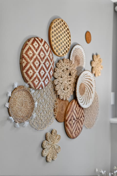 Handcrafted woven wall decor featuring circular designs in various textures and neutral tones.