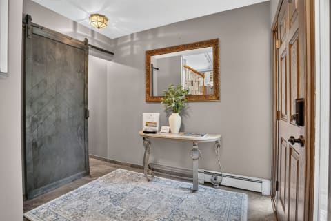 Elegant entryway with a barn door, console table, and decorative mirror.