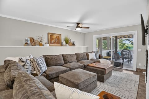 Cozy living room with a large sectional sofa, decorative elements, and a view of the porch.