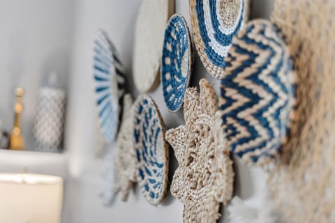 Collage of woven wall art in blues and natural fibers, creating a coastal ambiance.