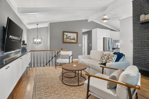A cozy living room featuring a light sofa, colorful throw pillows, a wooden coffee table, and modern decor.