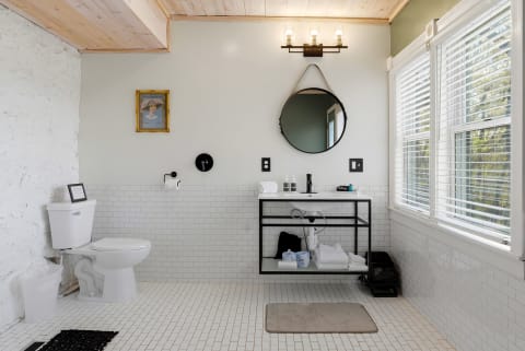 Relax in your spa-inspired bathroom with a soaking tub, natural light, and white subway tiles. Warm wood ceilings and thoughtful design make your daily routine feel like a retreat.