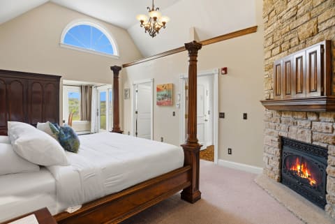Drift off in your elegant four-poster bed with a crackling fireplace, vaulted ceilings, and scenic views through your windows.
