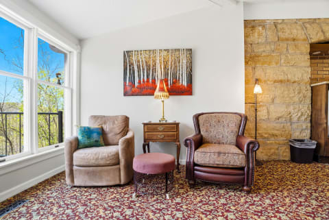 Curl up in cozy chairs by the stone fireplace or gaze out at the lush treetops through bright windows—your perfect spot to unwind after exploring.