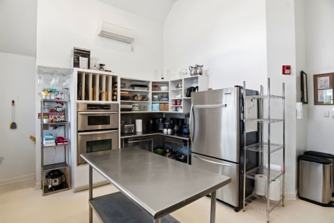 A well-equipped communal kitchen with commercial-grade appliances, ample storage, and spacious prep areas to easily whip up your favorite meals during your stay.