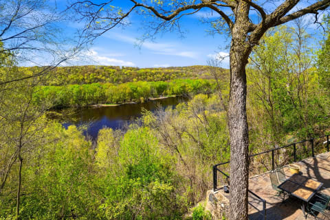 Scenic overlook showcasing serene lake views framed by lush spring foliage and rolling hillsides under a clear blue sky.