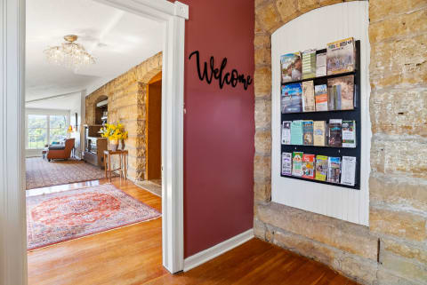 Welcoming entryway with stone arches, a welcome sign, and a display of local guides.