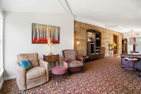 This inviting shared lounge features comfortable armchairs, warm artwork, and a striking stone accent wall with a built-in entertainment unit—perfect for your downtime between adventures.