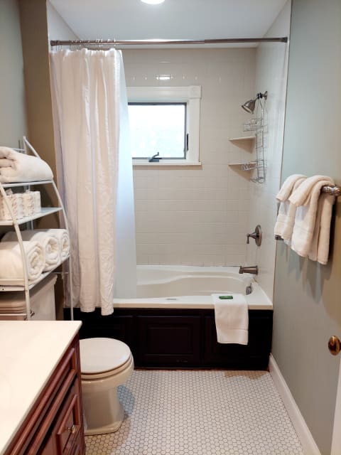 An inviting bathroom with a tub-shower combo, fluffy towels, and a bright ambiance.