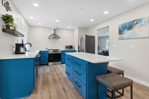 A modern kitchen showcasing blue cabinets and a stylish island.