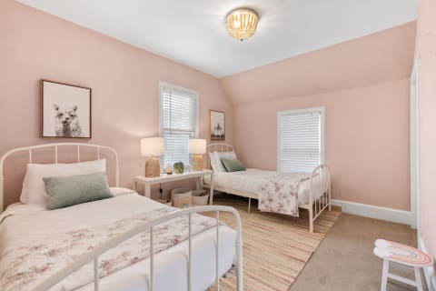 Twin bedroom with pink walls, floral bedding, and whimsical decor.
