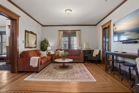 Cozy living room with plush sofas, a circular coffee table, and rich wooden details.