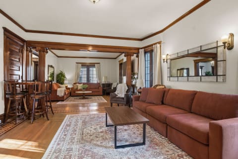 A cozy living room with rich wood details, plush sofas, and elegant decor, providing a warm retreat.
