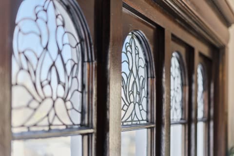 Close-up view of stained glass windows with floral designs in a wooden frame.