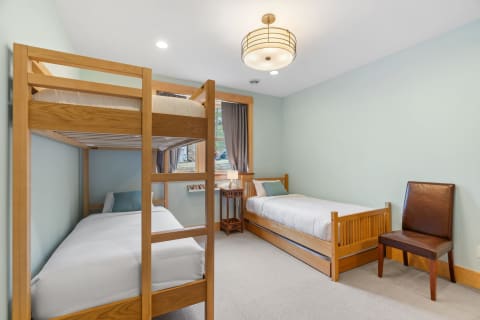 Children's bedroom with a bunk bed, single bed, and warm lighting.