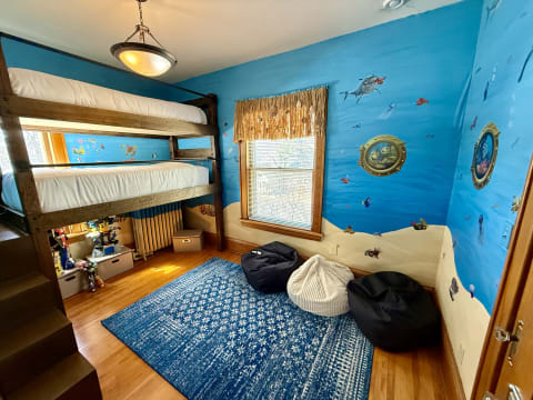 Children's room featuring a wooden bunk bed and marine-themed murals.