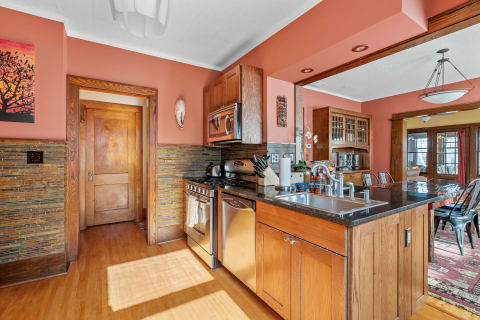 Interior view of a kitchen featuring peach walls, wooden accents, and modern appliances.