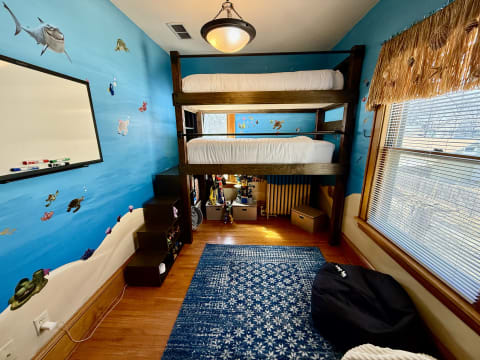 Ocean-themed children's bedroom with bunk bed and marine life on the walls.