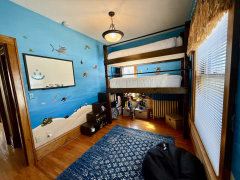 A bright, colorful children's room featuring a bunk bed and underwater-themed decorations.