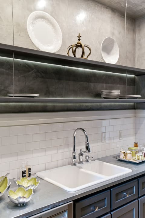 Modern kitchen featuring open shelving with decorative plates and a spacious farmhouse sink.