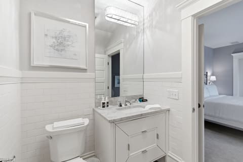 Clean and modern bathroom with white subway tiles and a marble vanity.