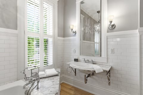 Elegant bathroom with white subway tiles, freestanding tub, and marble vanity.