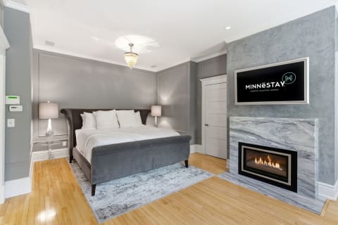 Elegant bedroom with a king bed, gas fireplace, and modern decor.