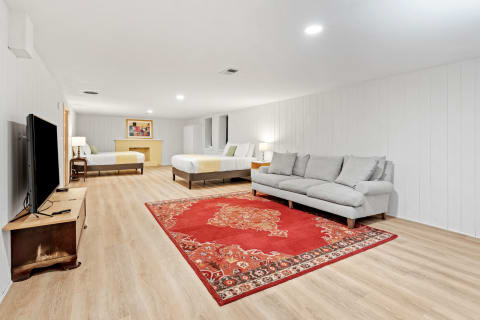 Spacious basement area featuring two beds and a comfortable sofa.